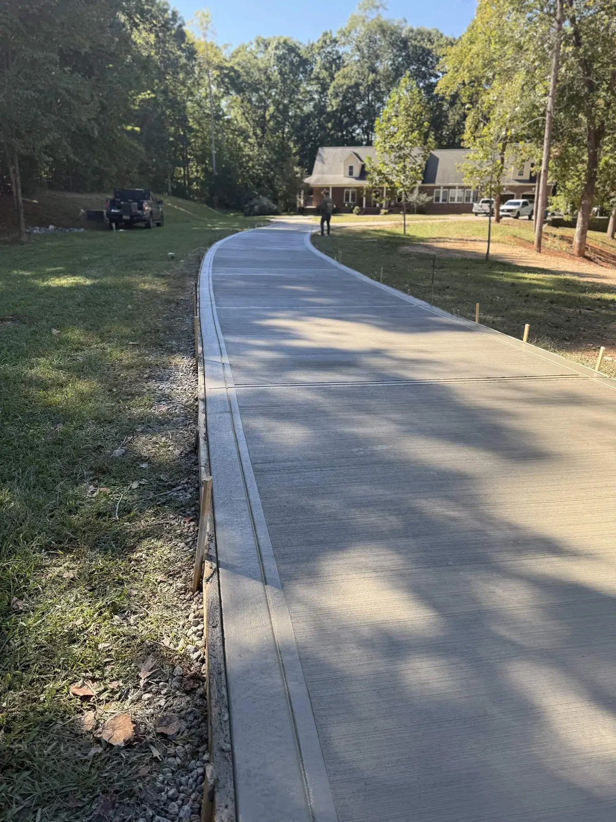 Newly poured concrete driveway curving up to a home near Lake Norman